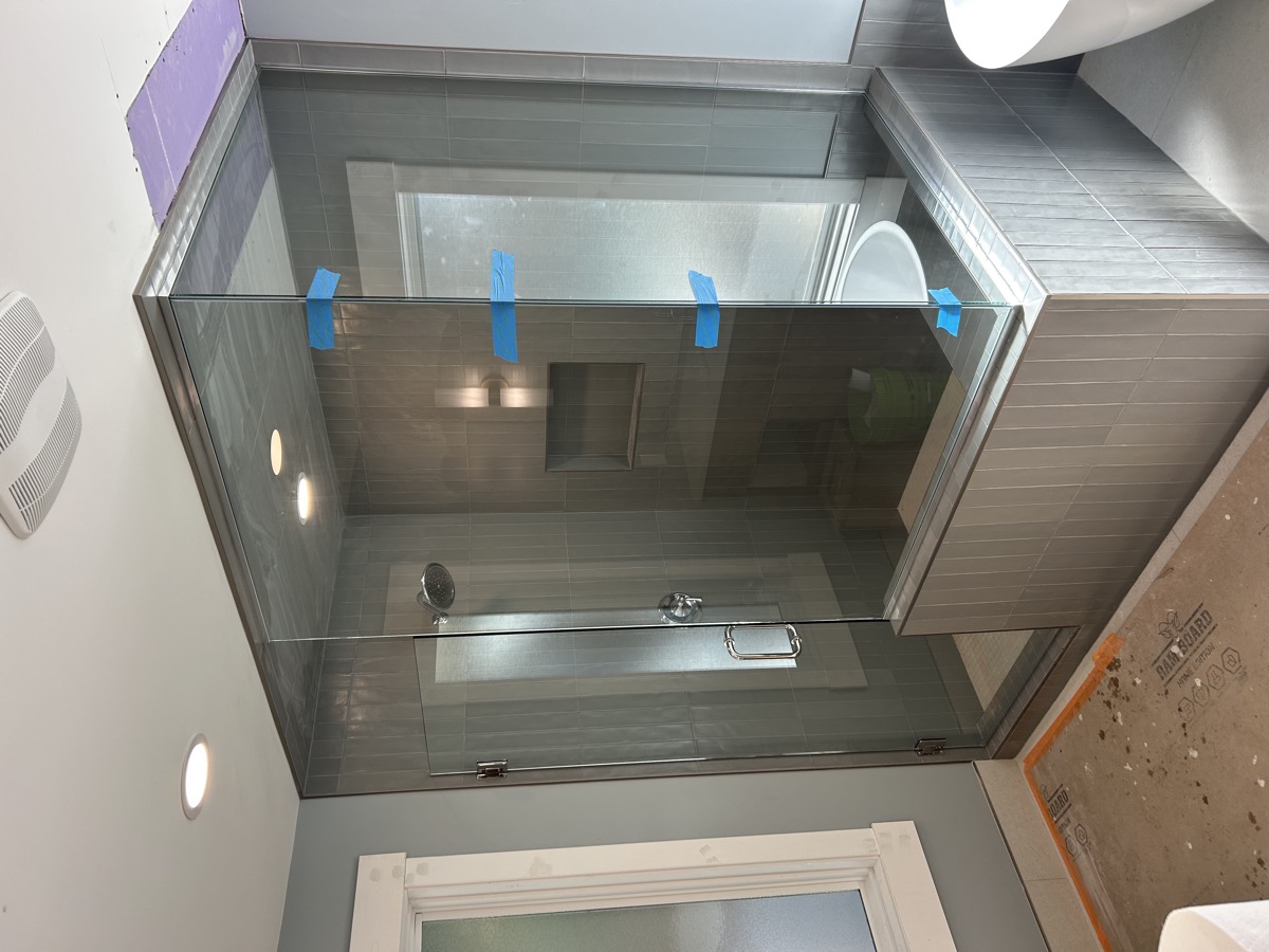 Frameless shower enclosure with modern fixtures
